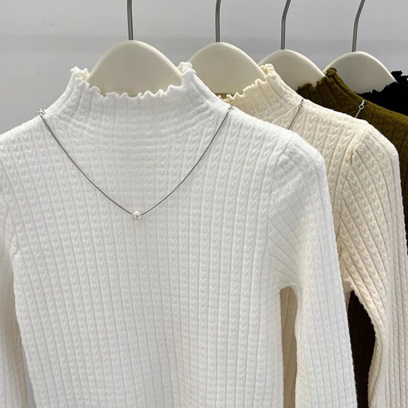 レースのハーフタートルネックの気品のある暖かいニットセーター、冬に快適で多用途な白い長袖プルオーバー
