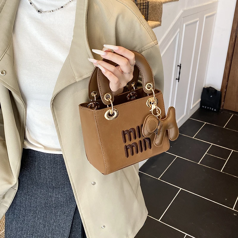 

Элегантная дизайнерская сумка для подгузников премиум-класса: классическая кожаная сумка через плечо однотонного цвета с логотипом для стильных женщин.