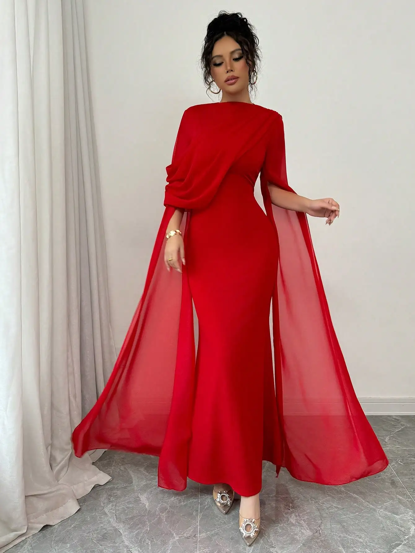Robe longue asymétrique rouge avec manches cape transparentes et détails plissés