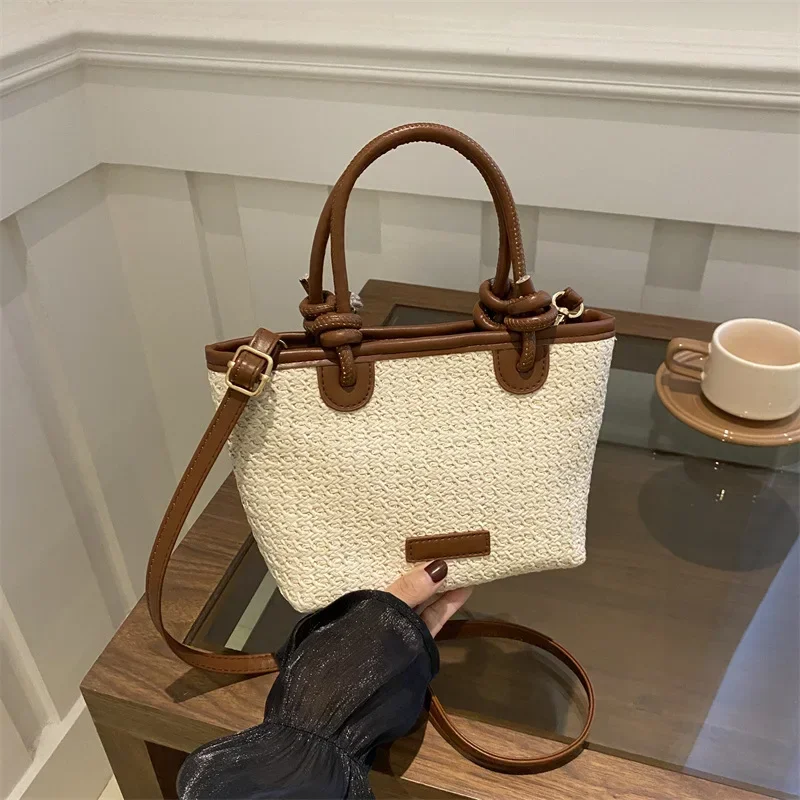 

Pastoral hand-held straw bucket bag women's light luxury niche high-end messenger woven bag