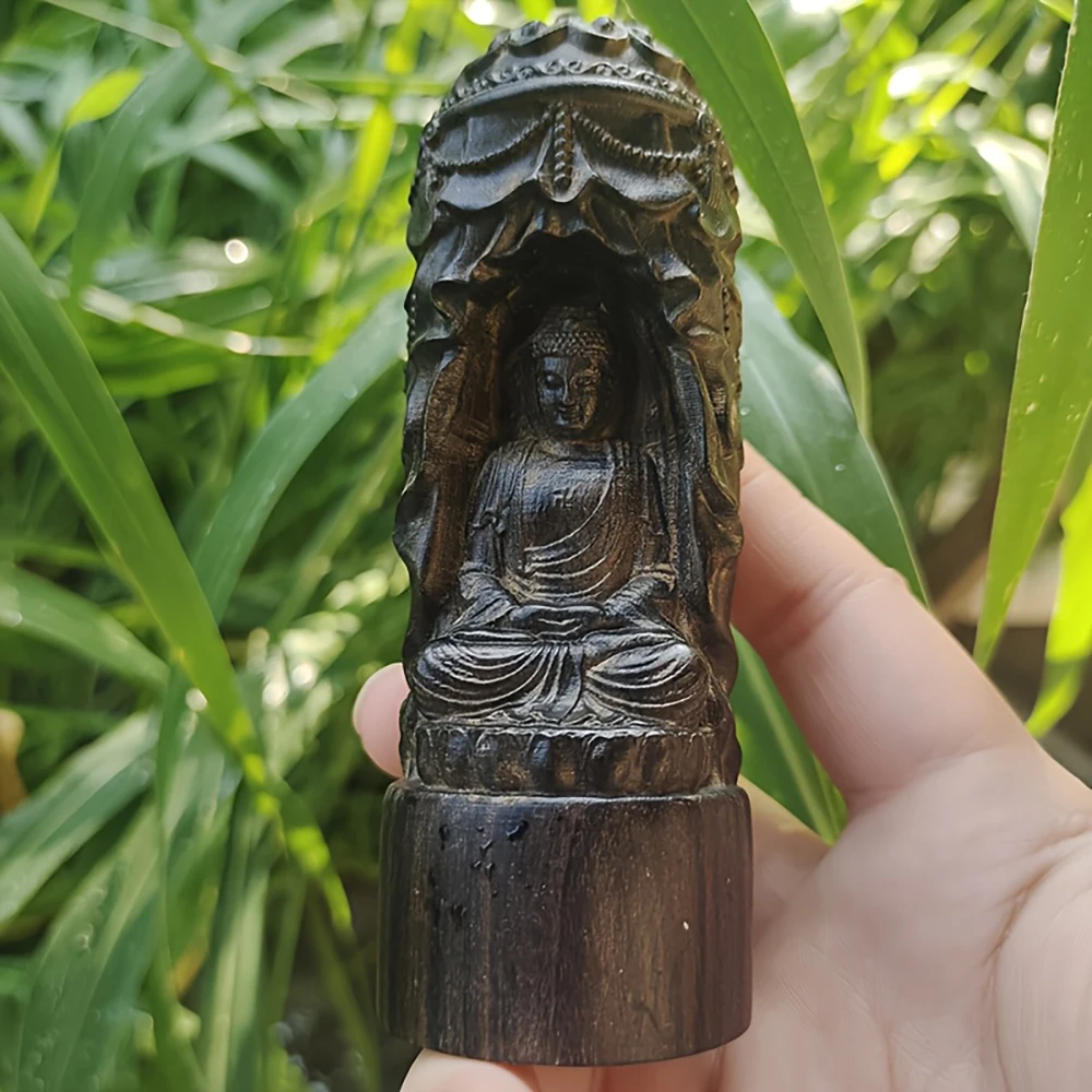 Statue de Bouddha sculptée en bois de style sanctuaire avec un daisonnier recouvert d'un rideau et de motifs floraux, doté d'un daisonnier délicatement sculpté. Le Bouddha est assis en position de lotus avec des motifs vestimentaires lisses et élégants et une expression pleine de compassion. La base de la colonne est simple, offrant un décor d'inspiration zen pour la maison ou le bureau.