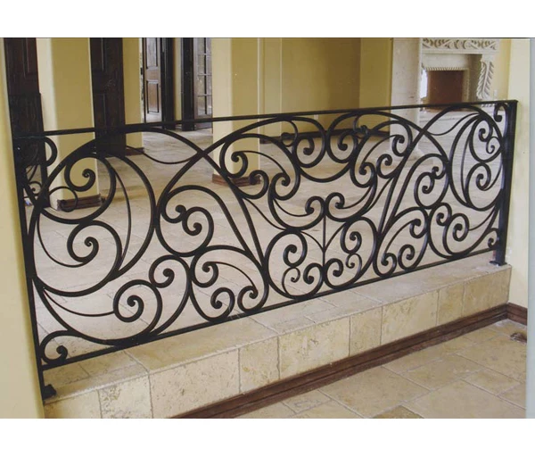 Antique wrought iron indoor staircase balustrade with wooden handrail