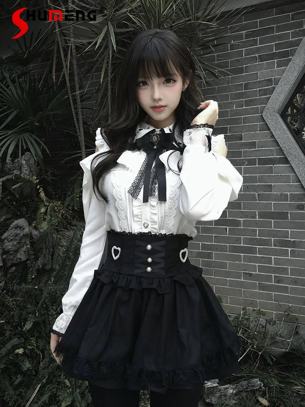 

Японский комплект в стиле минимализм: блузка с длинным рукавом, кружевным бантом и пуговицами, юбка с завышенной талией и бантом в форме сердца для женщин