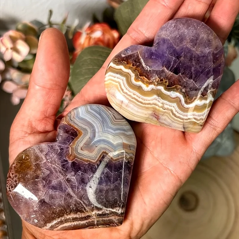 A unique heart-shaped amethyst lace agate carving with natural pits and cracks on the surface, characteristic of agate stones.