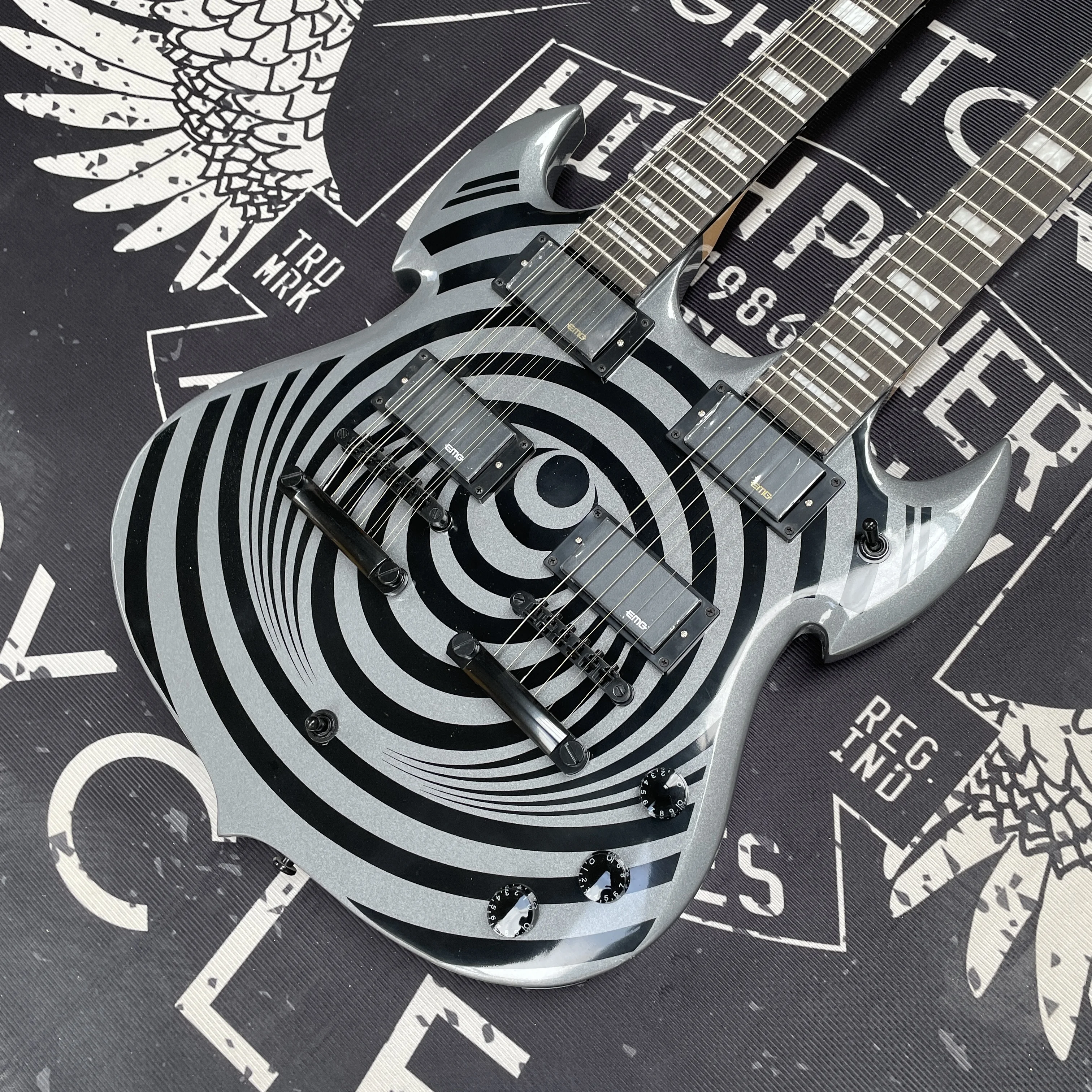 

Электрогитара серого цвета, стабильно устроенной конструкции и с мощным звучанием, с двойными звукоснимателями.