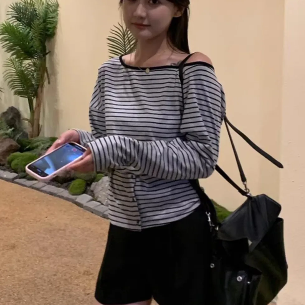 قميص نسائي بأكمام طويلة للربيع والخريف بتصميم بسيط بكتف واحد وياقة مشقوقة مع تفاصيل أزرار وخطوط، مناسب للارتداء اليومي