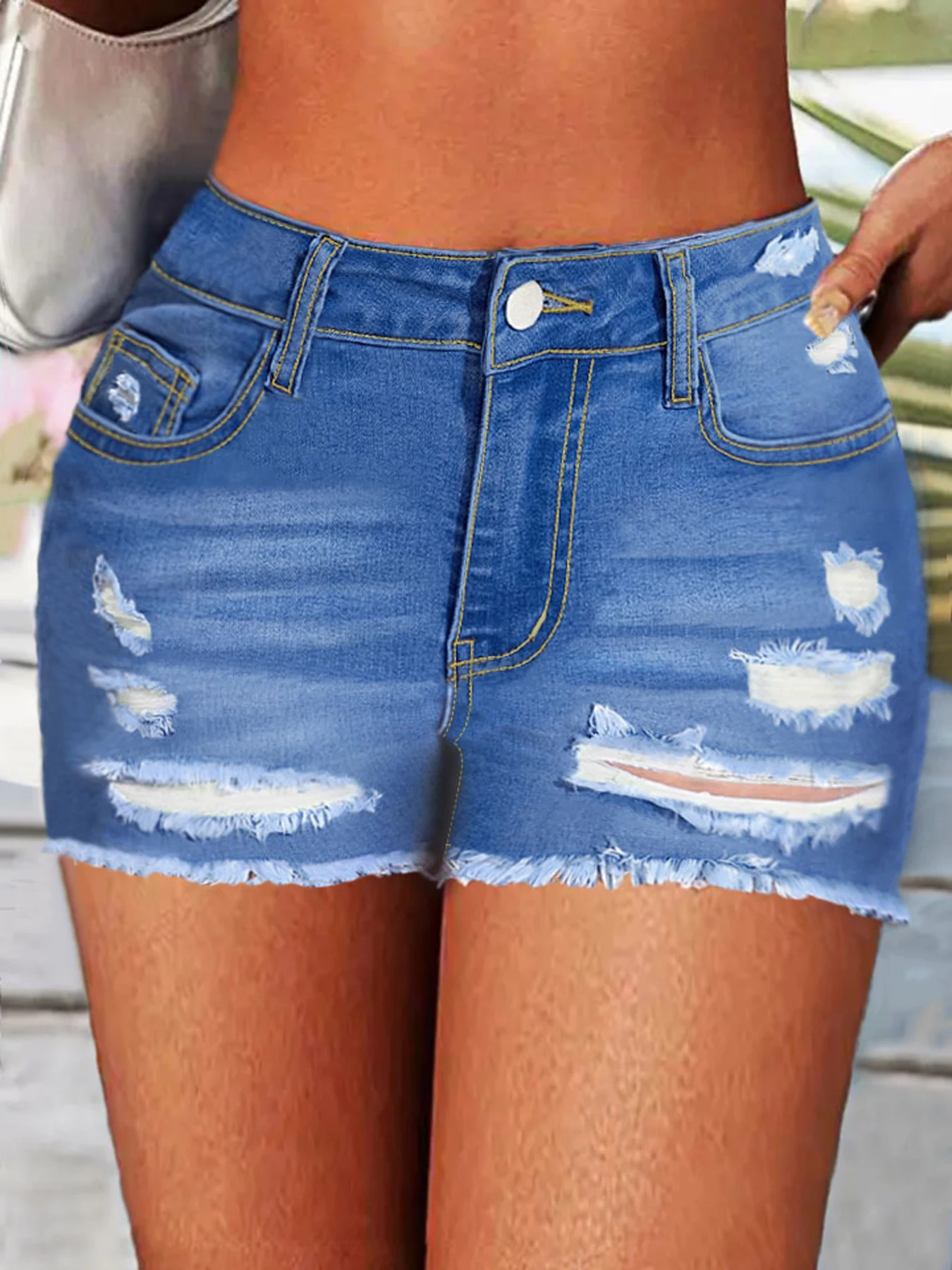 Pantalones cortos de mezclilla de cintura alta para mujer con un diseño desgastado desgastado en azul claro, adecuados para un estilo callejero moderno.