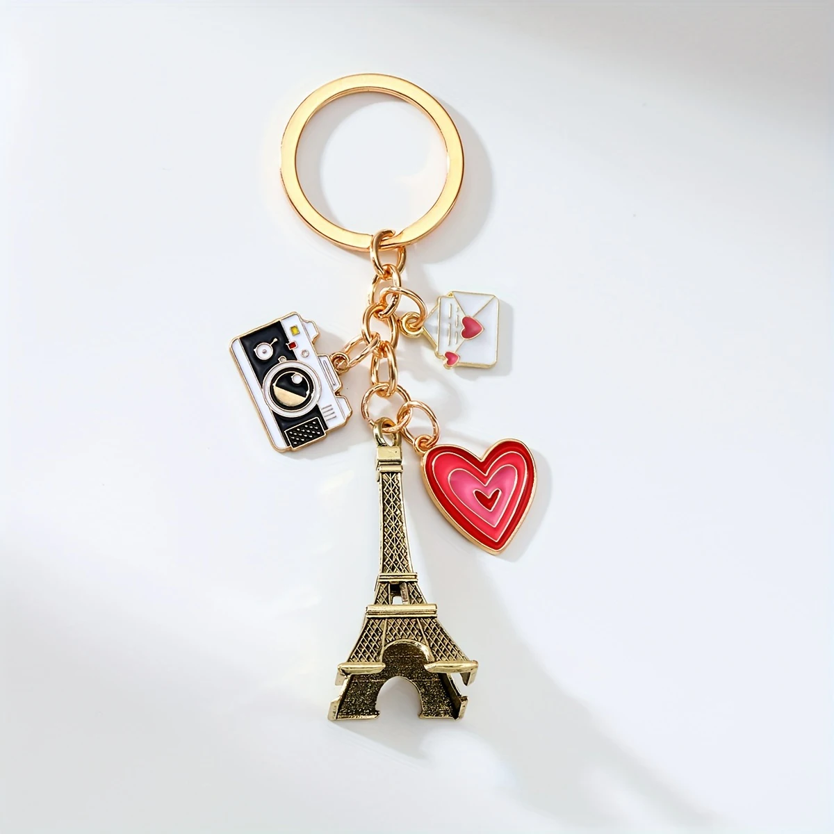Elegante llavero de aleación de hierro con dijes de la Torre Eiffel, corazón y cámara. Un regalo de San Valentín sin deslustre para parejas. Tono dorado.