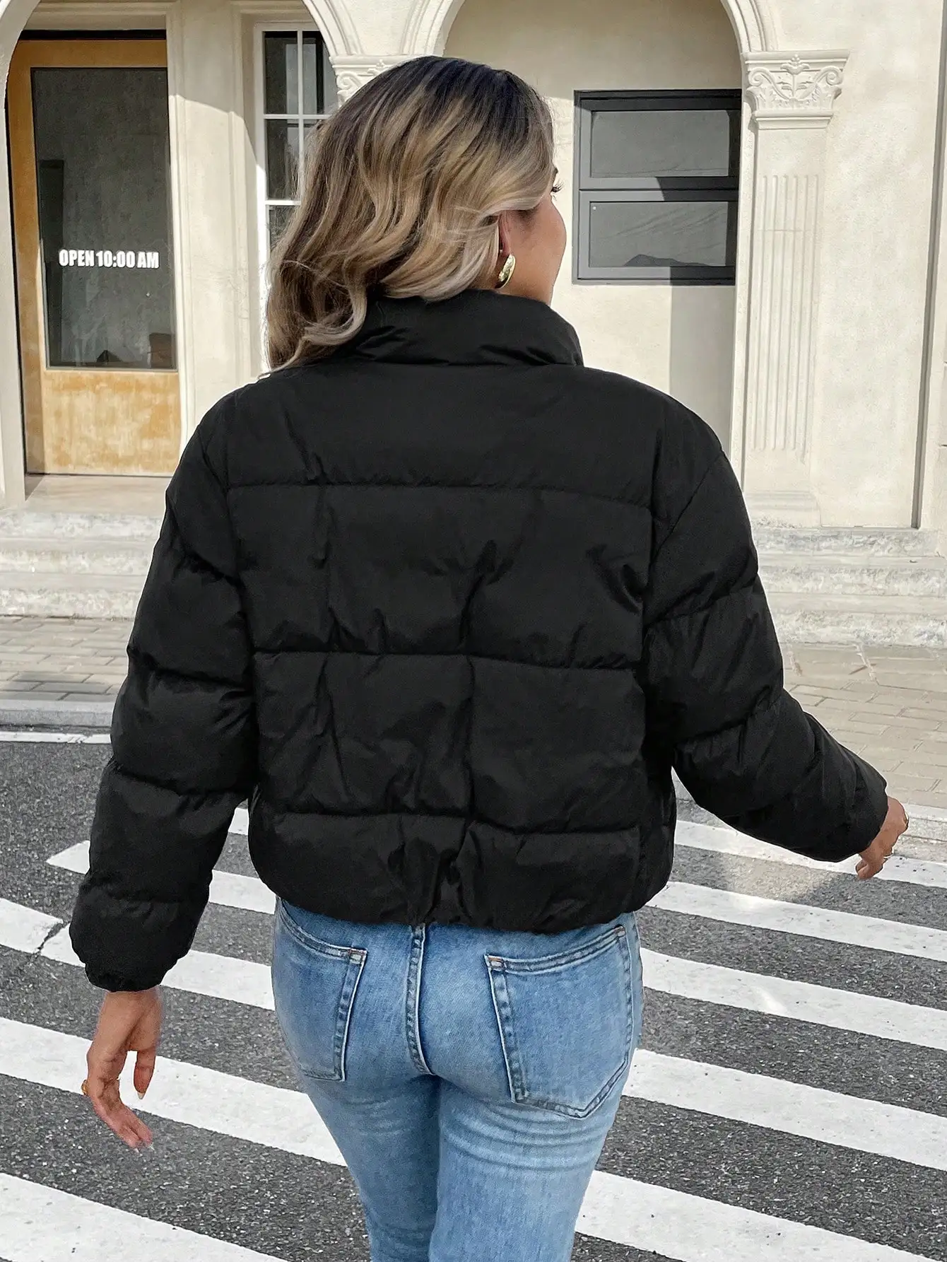 Damska czarna krótka kurtka bomberka puchowa ze stójką i zapinana na zamek z przodu, idealna na zimę.