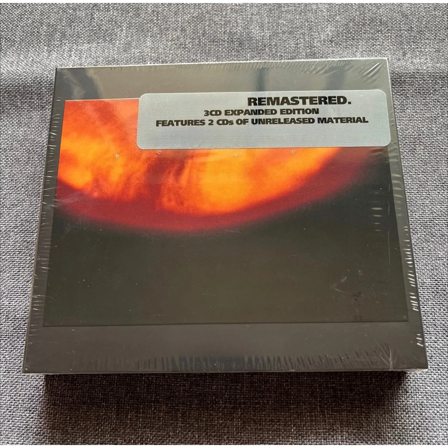 CD audio con brani rock intensi, copertina astratta con effetto luminoso arancione e rosso, disco di musica rock per gli amanti della musica e i colle