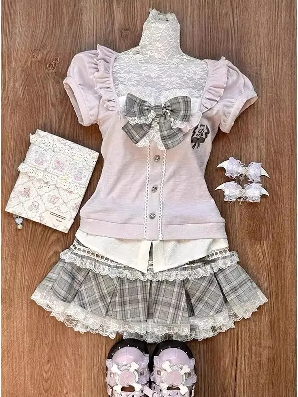 Ensemble deux pièces pour femme comprenant un haut rose en dentelle patchwork avec grand nœud et manches bouffantes, et une jupe plissée à taille haute à carreaux gris, style Lolita, style japonais doux et girly, style soft girl, style JK, style Harajuku, style princesse, rétro et mignon, effet rajeunissant, amincissant, tenue ajustée pour le printemps et l'été, idéal pour le quotidien, les rendez-vous, le shopping, les séances photo, les soirées, les conventions d'anime, style universitaire, fille bidimensionnelle, style uniforme scolaire, tenue tendance avec décoration en nœud, bordure en dentelle, jupe plissée à carreaux, fille à la fois douce et cool.