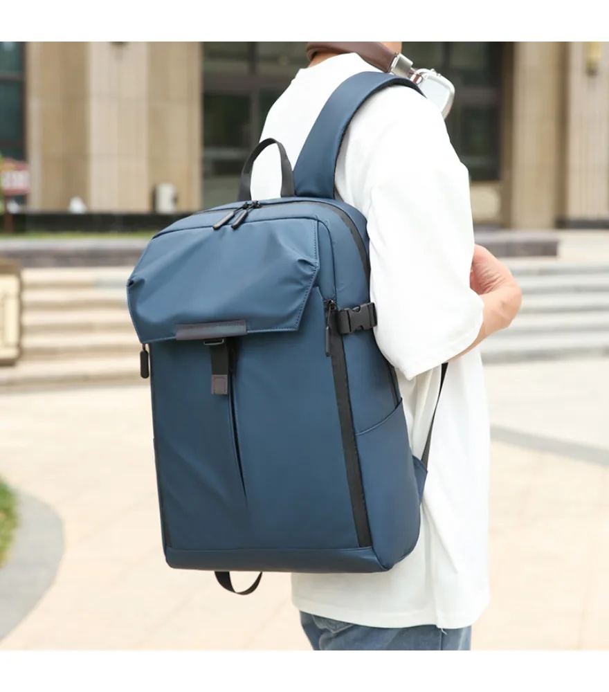 Blue workwear style backpack roll top closure with buckle strap side compression pockets matte waterproof surface suitable