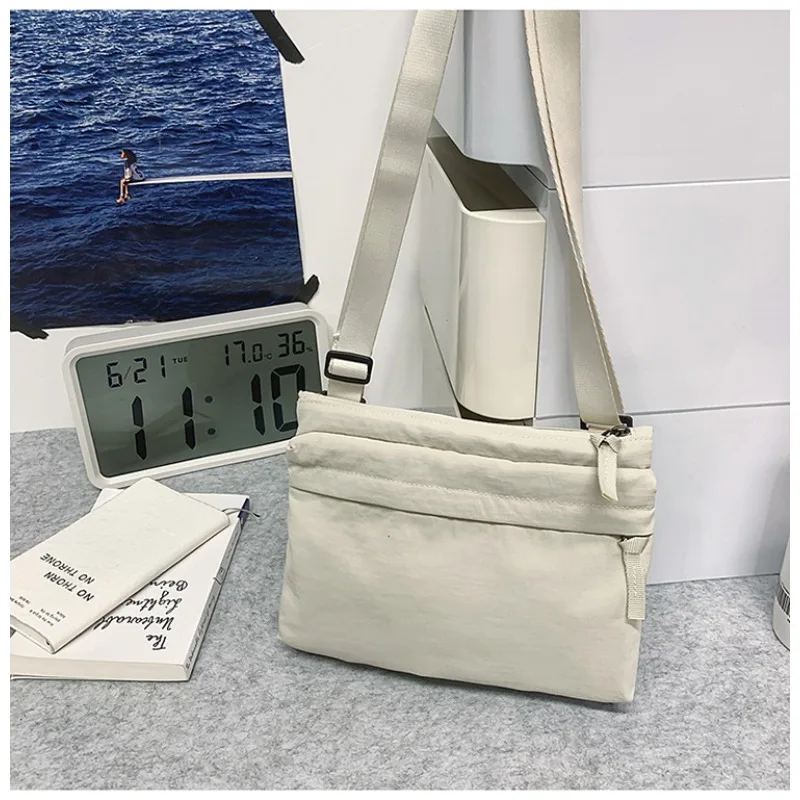 

Нейлоновая сумка через плечо с застежкой-молнией и множеством карманов, с регулируемыми ремнями для ношения как портативная сумка через плечо.