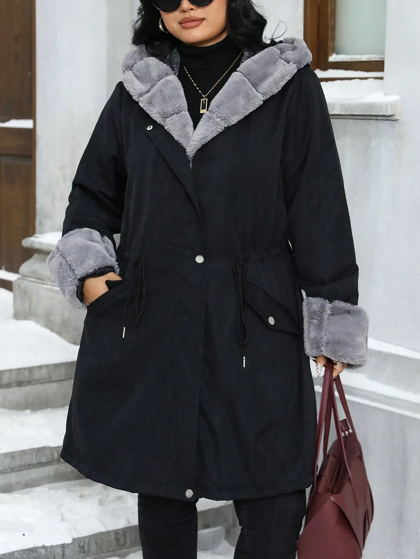 Damski płaszcz zimowy plus size z kapturem, wykończeniem z sztucznego futra, marszczoną talią i zapięciem na zamek błyskawiczny.