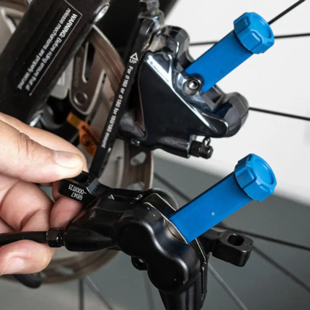 أداة توزيع وسادة فرامل الدراجة الفولاذية المتينة 360 درجة °   مكبس قرص زيت الدراجة القابل للدوران، إعادة تعيين تمديد مكبس الفرامل الهيدروليكية