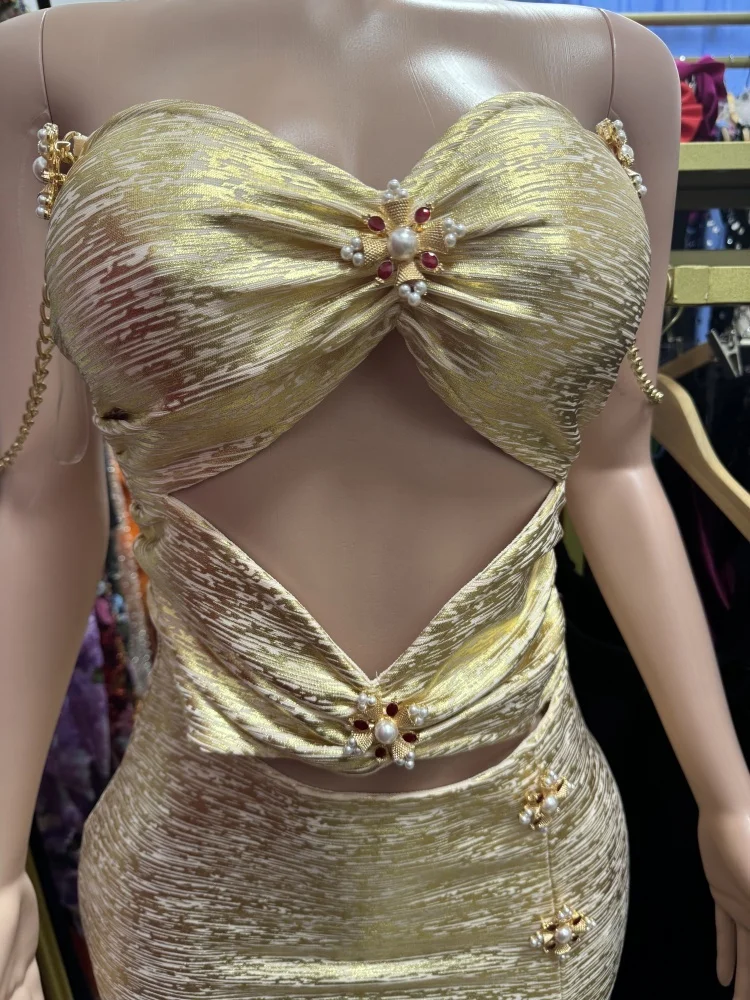 新しい高品質でセクシーなゴールドのワンショルダーカラードレス。背中が露出するカットアウトデザイン、プリーツ、ゴールドカラーが特徴です。