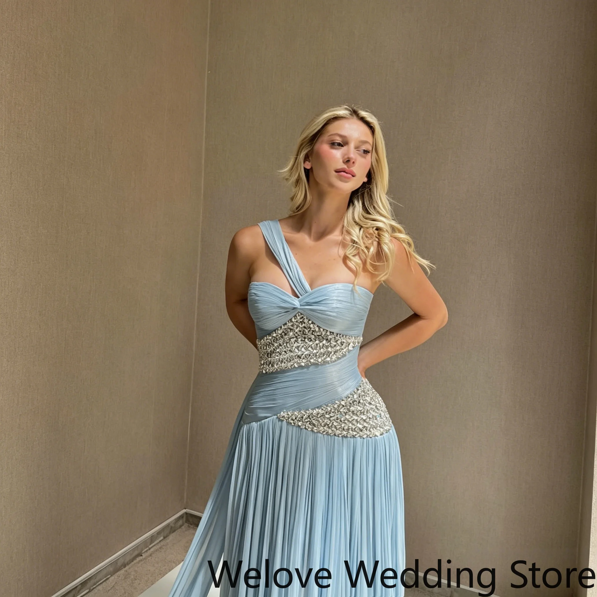 Light Blue Formal Evening Gown Featuring a One-Shoulder Neckline, Ruched Bodice, and Asymmetrical Crystal Embellishments