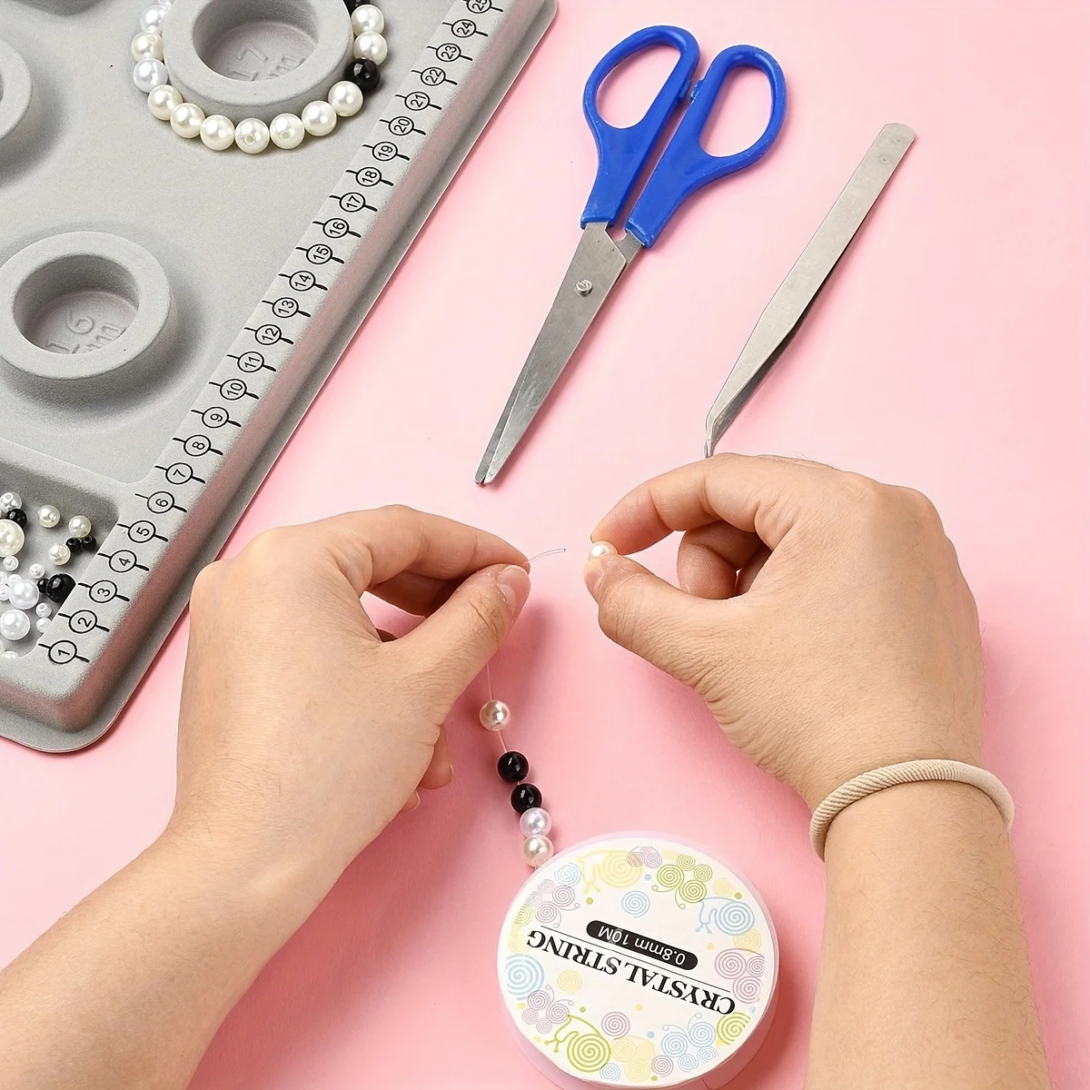 A small plastic jewelry tray with DIY bead threading tool, perfect for crafting bracelets and necklaces