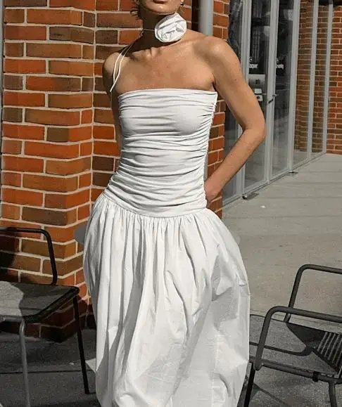 Biała sukienka bez ramiączek z odkrytymi ramionami, dopasowana, z niskim stanem, letnia sukienka bez rękawów z kwiatowym zdobieniem.