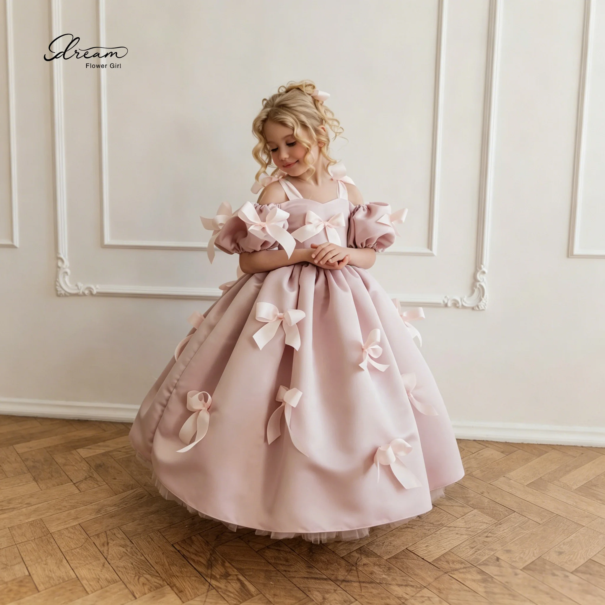 

Pink floor-length formal princess dress for girls featuring cape sleeves a voluminous skirt and bow accents