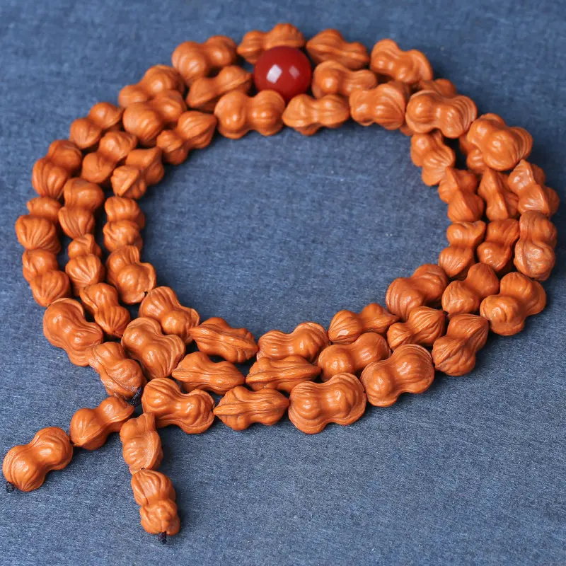 Long string of peach pit bracelets with dragon patterns from old trees for men featuring uniquely shaped peanut gourd walnut
