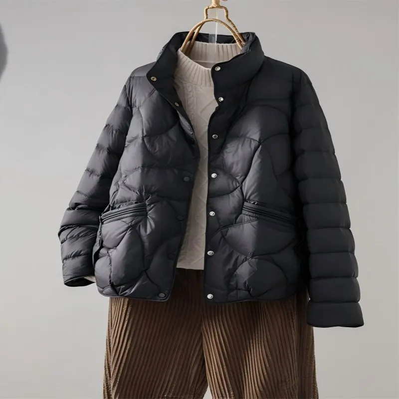 سترة منتفخة أنيقة بدون جهد. ملاءمة مريحة مع ياقة واقفة. أسلوب قصير متعدد الاستخدامات للتخسيس بلون سادة.