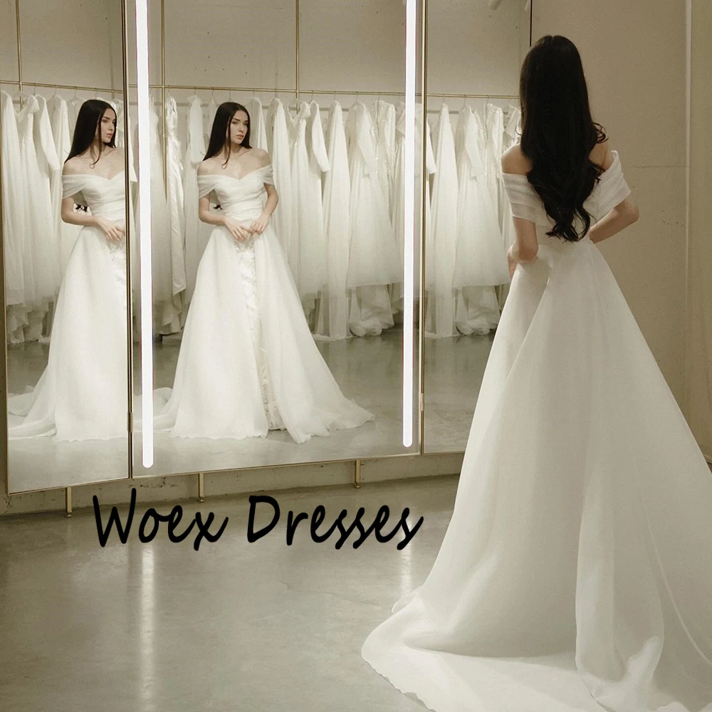 Suknia ślubna z organzy w kolorze białym, z odkrytymi ramionami, aplikacjami, trenem Watteau, odkryte plecy, fason A-line, długość do podłogi.