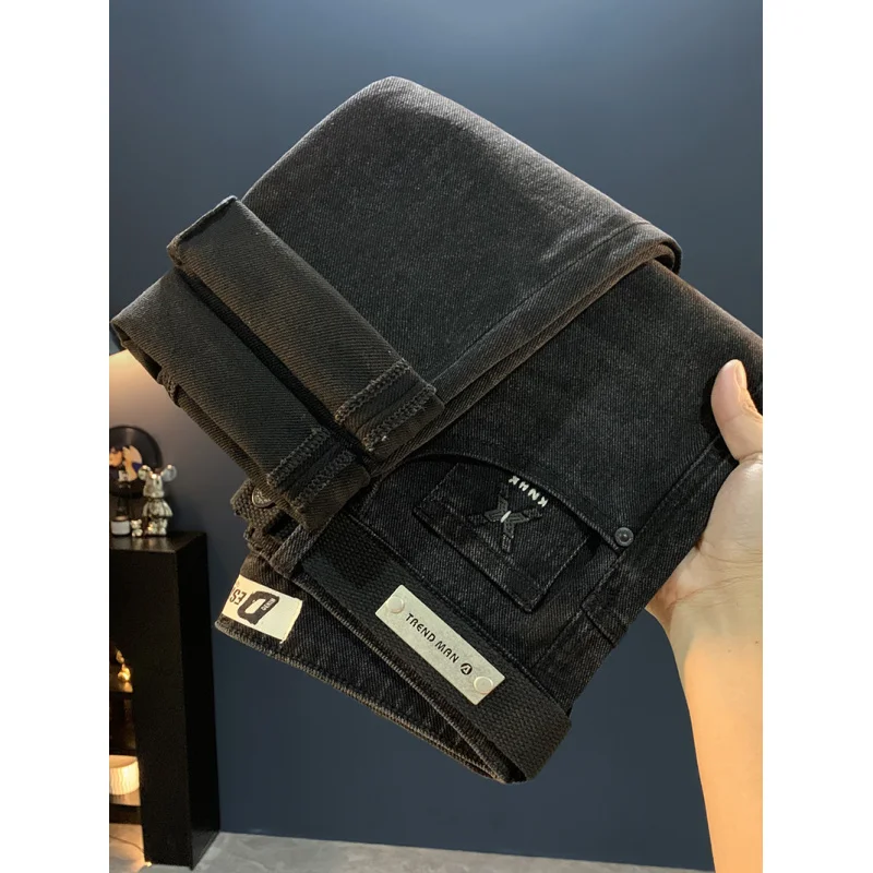 جينز أسود للرجال 2025 خريف جديد ملابس للرجال الراقية العلامة التجارية العصرية القدم الصغيرة عادية مطاطا بنطال ملاصق للجسم