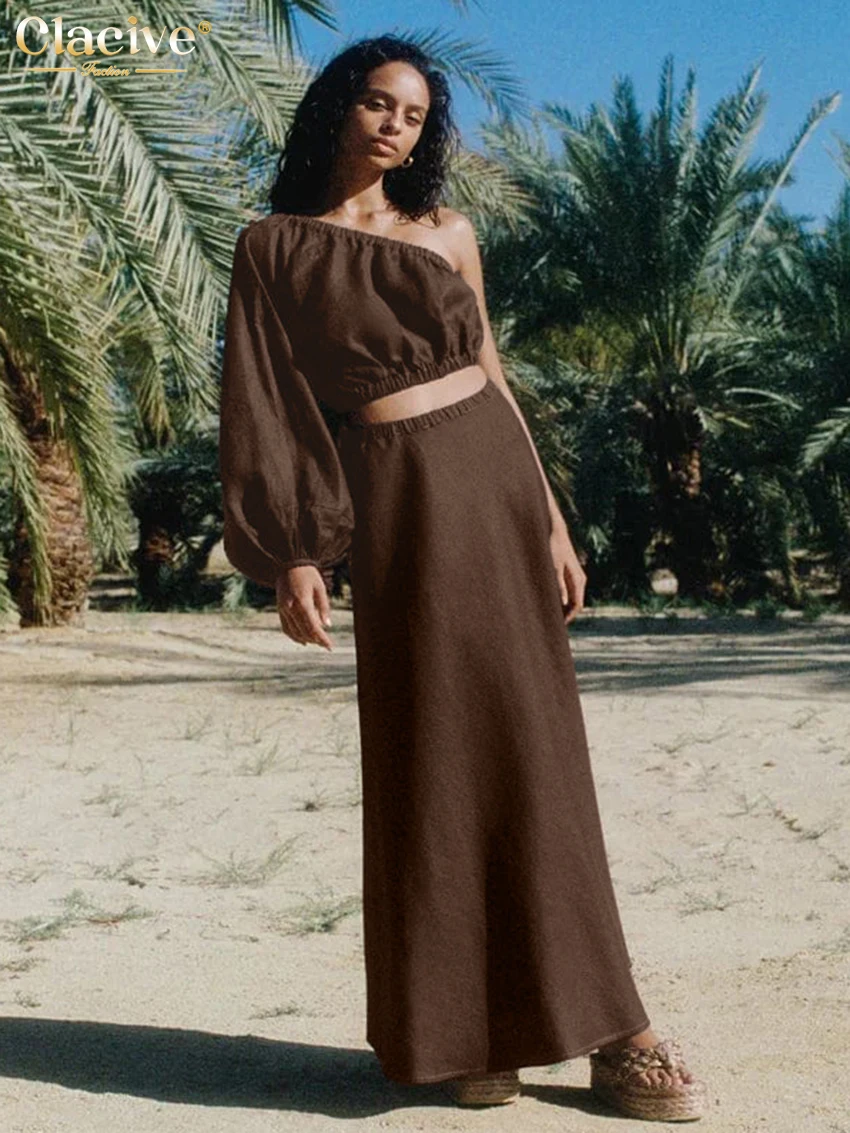 

Комплект Clacive: Элегантная хлопковая блузка с одним открытым плечом и длинным рукавом и длинная юбка с высокой талией, коричневый, 2 предмета, женский, весна 2026