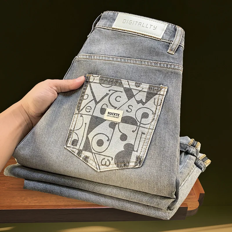2025年春夏のメンズジーンズ、小さな足のプリント、ゆったりとしたカジュアルなストレッチデニム、ロングパンツ