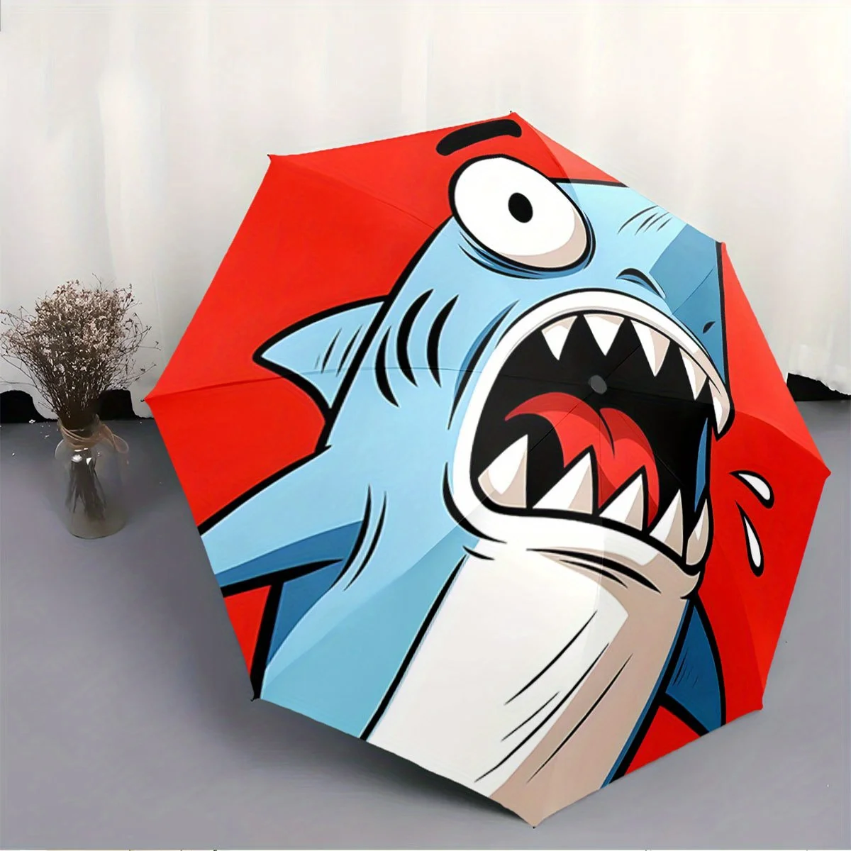 

Складной зонт с изображением мультяшной акулы с преувеличенным выражением, на ярко-красном фоне. Креативный портативный складной зонт, подходящий для использования.