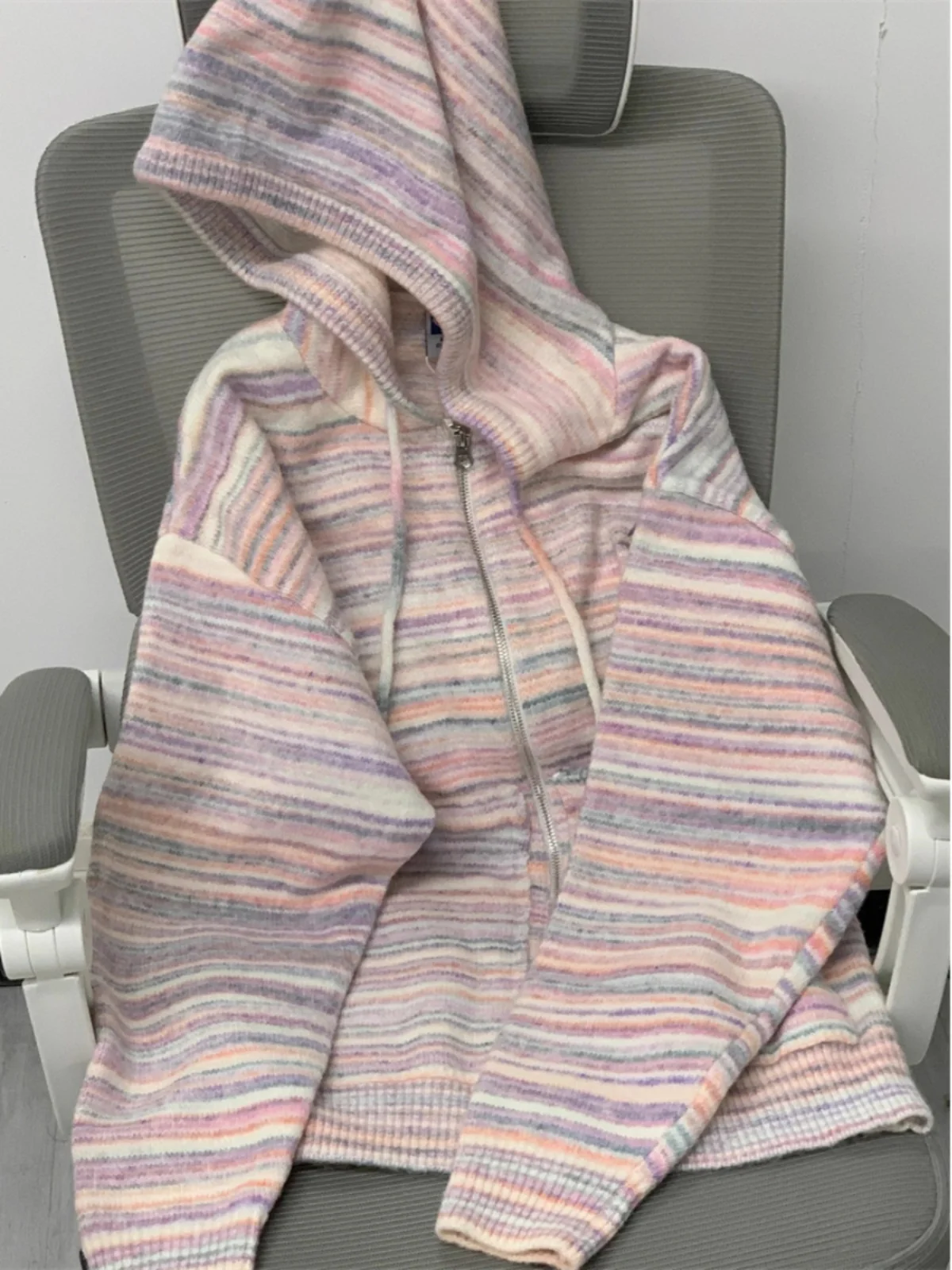 Elegancki sweter z kapturem, dzianinowy, damski, jesienno-zimowy, luźny krój, kolorowy, w paski, płaszcz, sofistyczny styl.