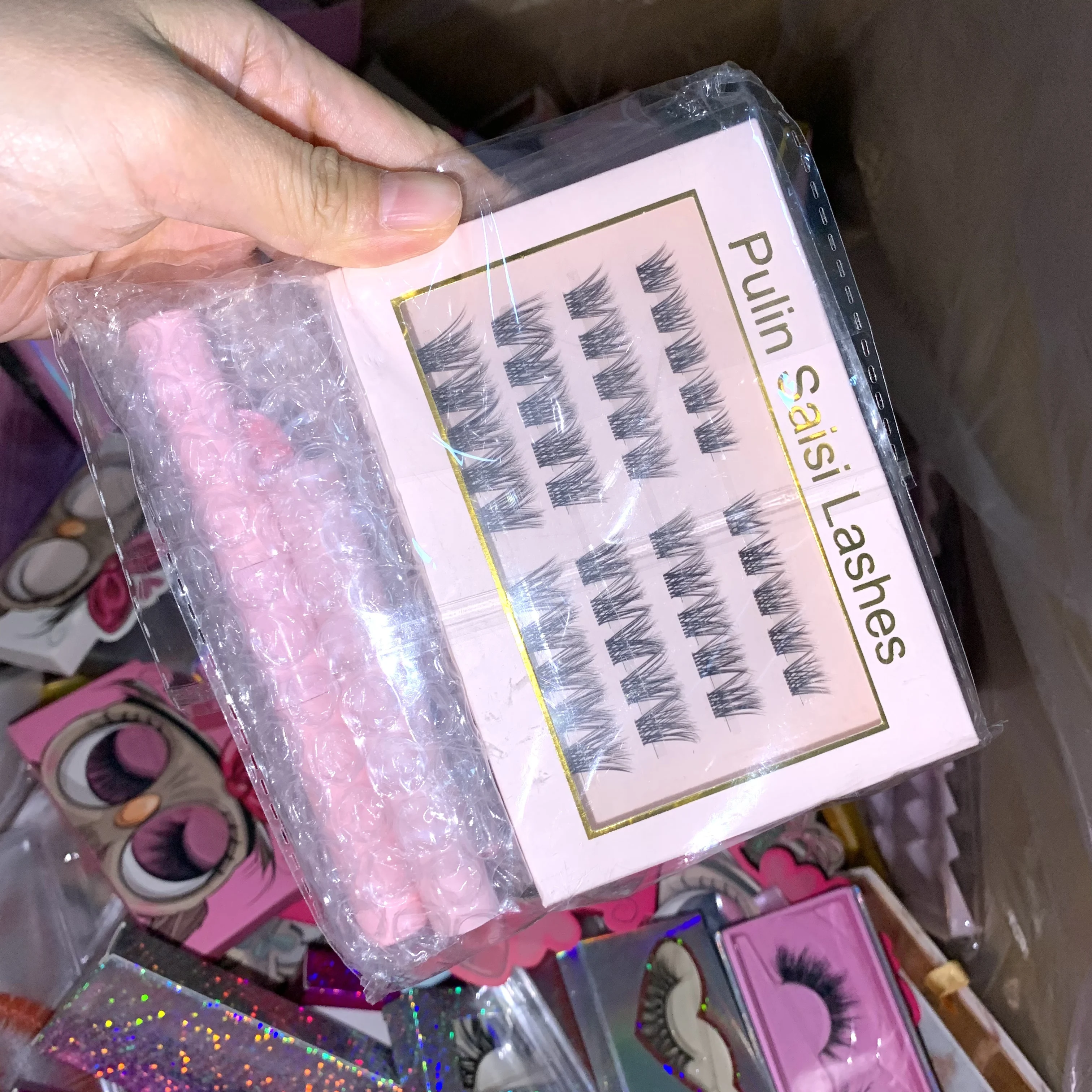 Pudełka Mystery Lashes, zawierają losowo sztuczne rzęsy, rzęsy w paski, rzęsy w klastry i narzędzia