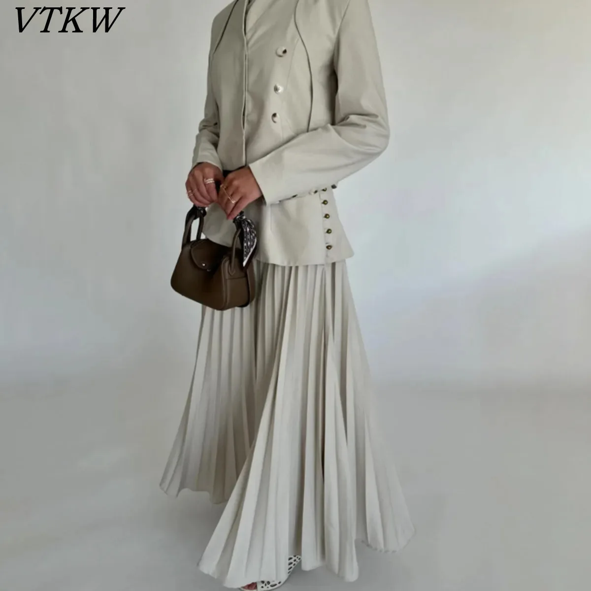 

VTKW 2026 Новый женский комплект из двух предметов: укороченный двубортный пиджак и асимметричная плиссированная макси-юбка с баской, бежевый наряд