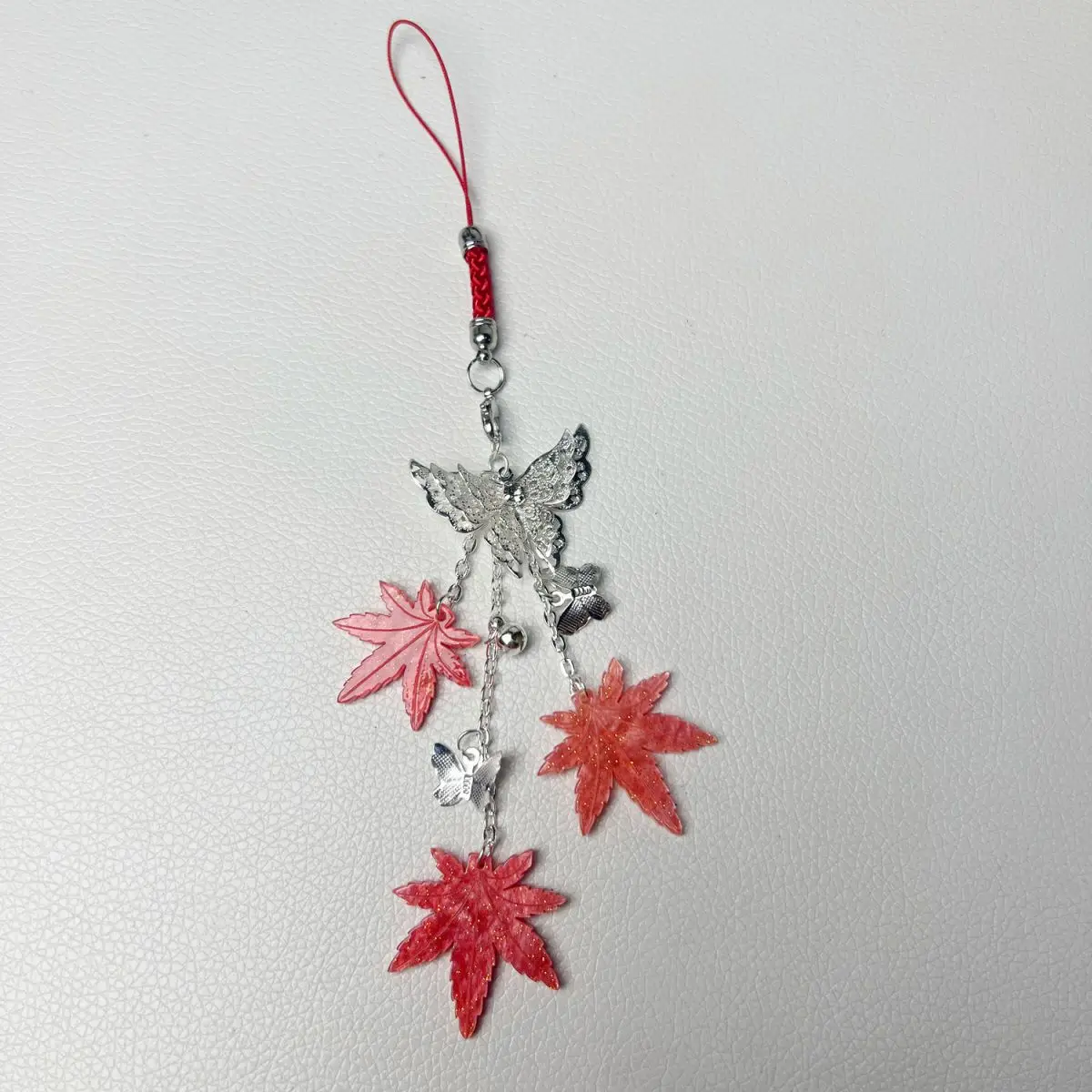 เทพธิดาสวรรค์ทรงพระราชากรุณาบุญคุณให้กับชาวเมืองดอกไม้ เซียเหลียน ด้วยเครื่องประดับรูปใบเมเปิ้ล กระดิ่ง และผีเสื้อสำหรับติดโทรศัพท์มือถือ