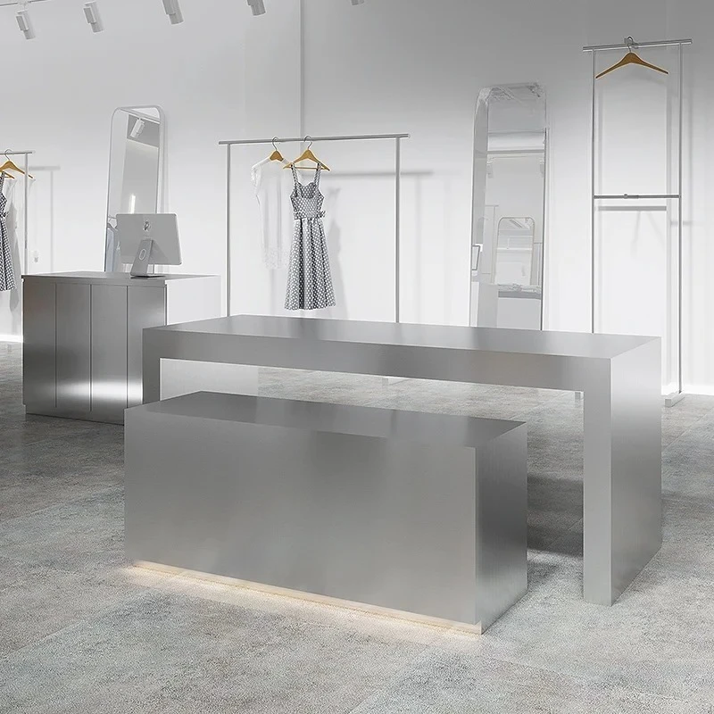 Stainless steel shoes and bags are placed in the middle of the Nakajima table in the clothing store. High and low display stands