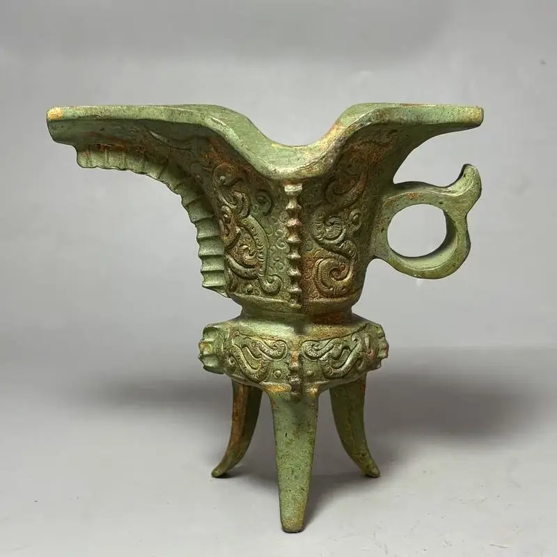 An unearthed green-rust patinaed Shang Dynasty three-legged wine cup with auspicious beast carvings, specially designed for king