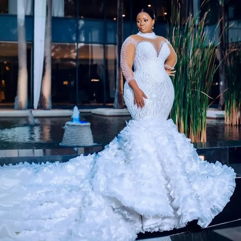 Suknia ślubna na zamówienie, biała, afrykańska, dla panny młodej, krój syreny, długie rękawy, zdobiona perłami i koralikami.