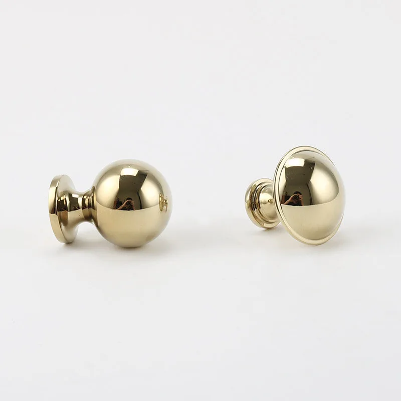 Two gold drawer knobs lying on their sides