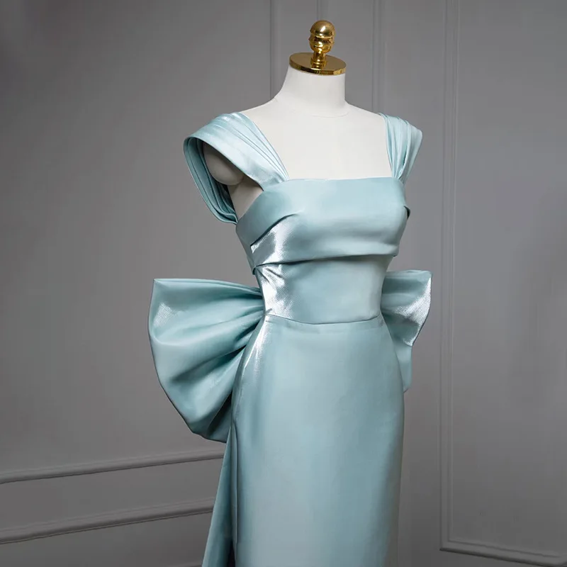 فستان سهرة نسائي من الساتان ذو ياقة مربعة بدون أكمام بتصميم نحيف للحفلات الراقصة والولائم بفيونكة كبيرة وذيل فيستدوس دي غالا