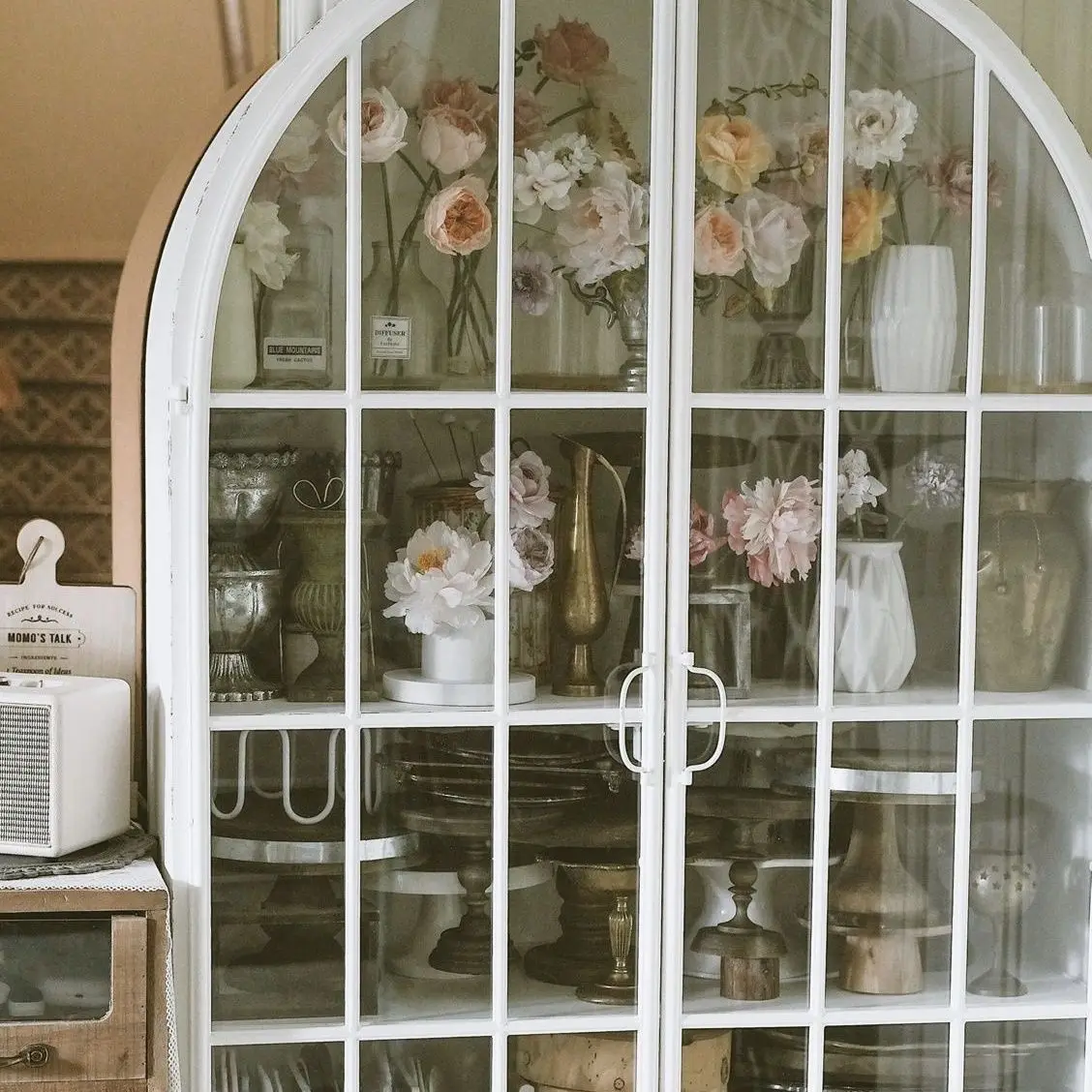 French retro iron arched mesh red bookshelf integrated with wall facing living room, floor standing storage cabinet