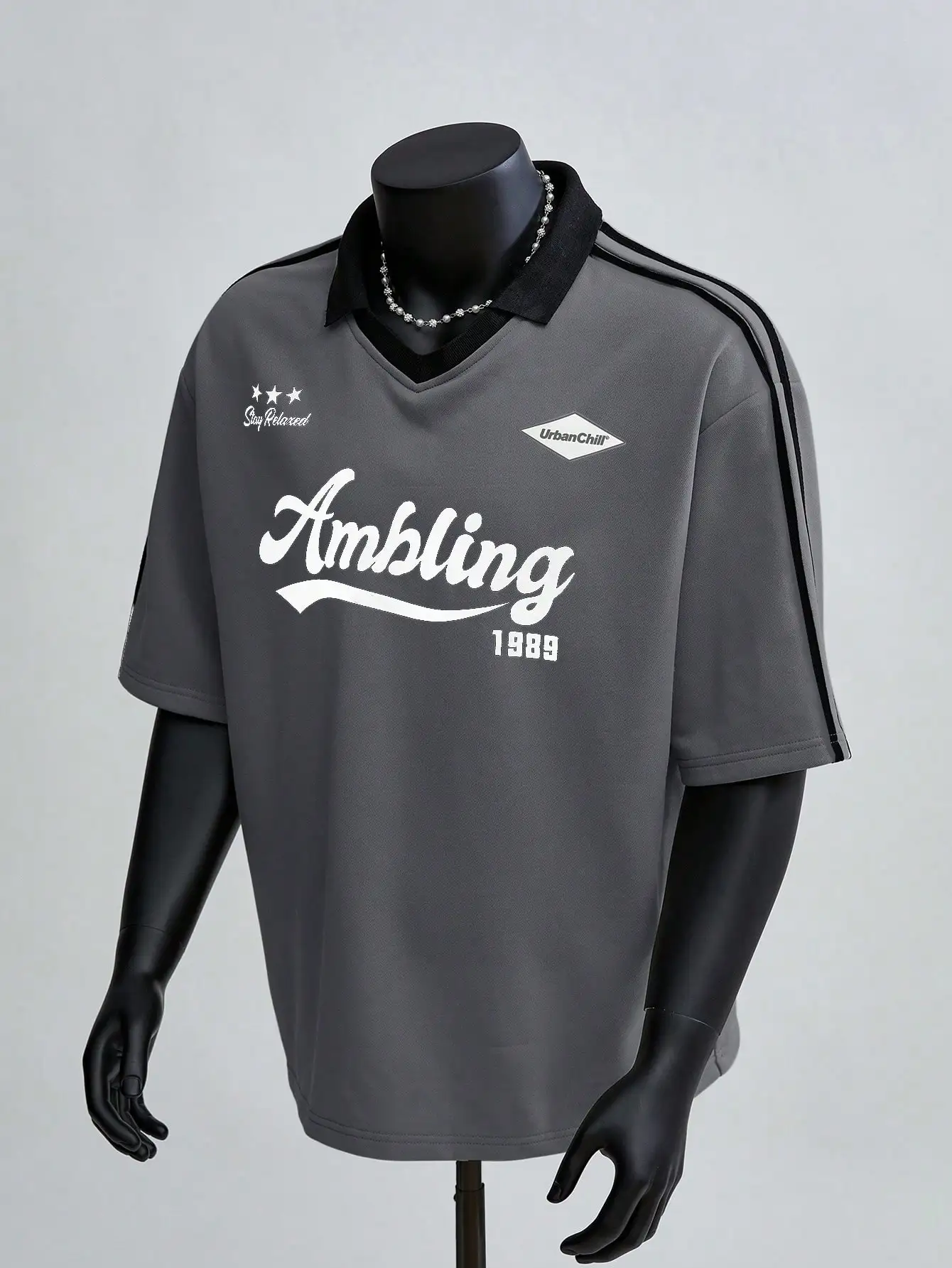 

Мужская серая рубашка-поло свободного кроя с V-образным вырезом, графическим принтом и полосатыми рукавами