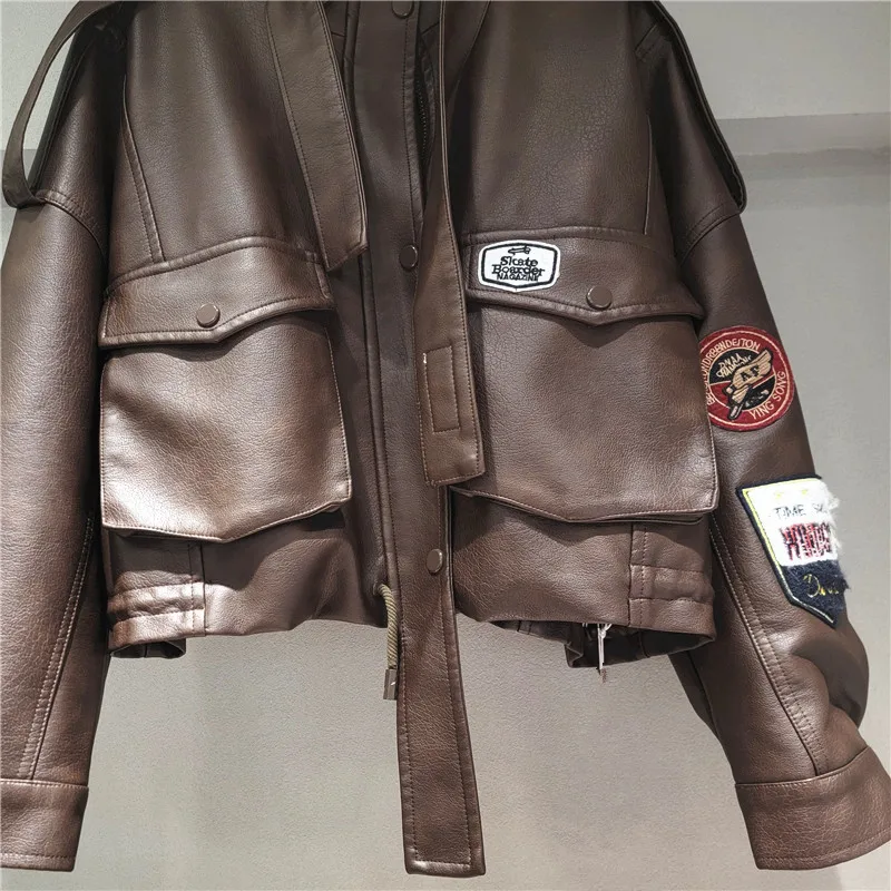 

Badge-patched brown PU jacket. Adjustable drawstring waist & cropped fit. Edgy biker chic with a feminine twist.