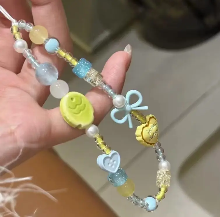 

One piece macaron color phone charm, fresh yellow & blue beaded strap with heart and bow ornaments. Suitable for phone, handbag