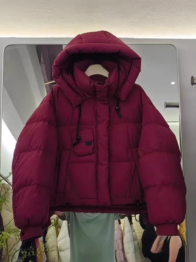 เสื้อแจ็คเก็ตขนเป็ดสำหรับผู้หญิง รุ่นใหม่ ปี 2025 ฤดูหนาว แบบสั้นมีฮู้ด สไตล์เกาหลี หนา ทรงขนมปัง อเนกประสงค์ ขนเป็ดขาว  เสื้อโค้ทแฟชั่น