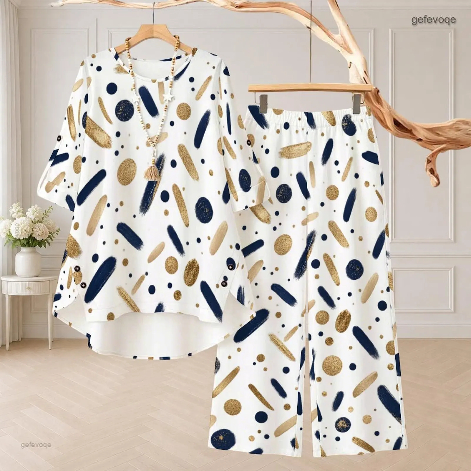 Conjunto de dos piezas para mujer: blusa de manga 3/4 con cuello redondo y estampado de lunares dorados sobre fondo azul marino, y pantalones de pierna ancha.