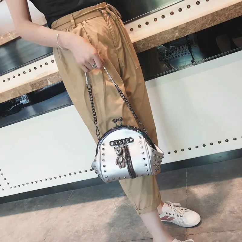 

Новая женская сумка-ракушка 2026 года в корейском стиле, универсальная, с цепочкой через плечо, с мультяшным кулоном и заклепками, портативная, в стиле Ins