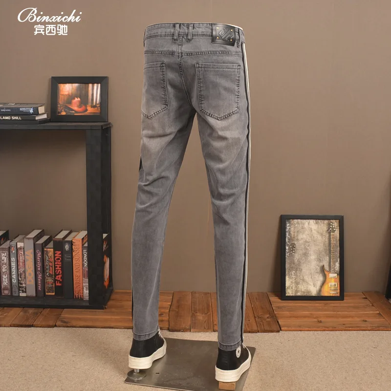 Celana jeans pria 2025 model baru trendi high-end elastis potongan ramping dengan hiasan pita rajutan bergaris
