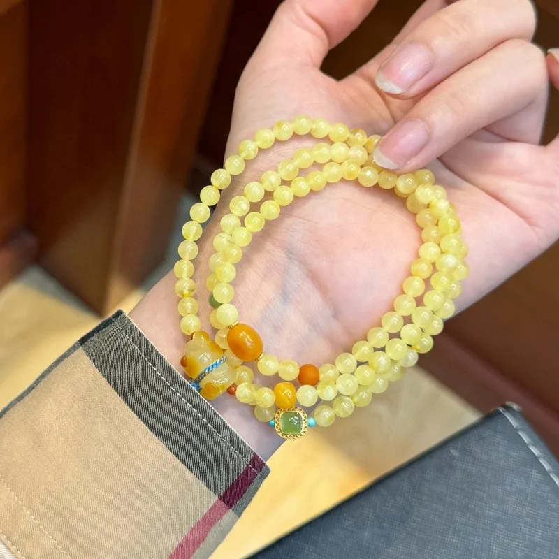 Natural Russian bracelet with three strands of beads featuring a small amber bear charm 5mm size made from raw am