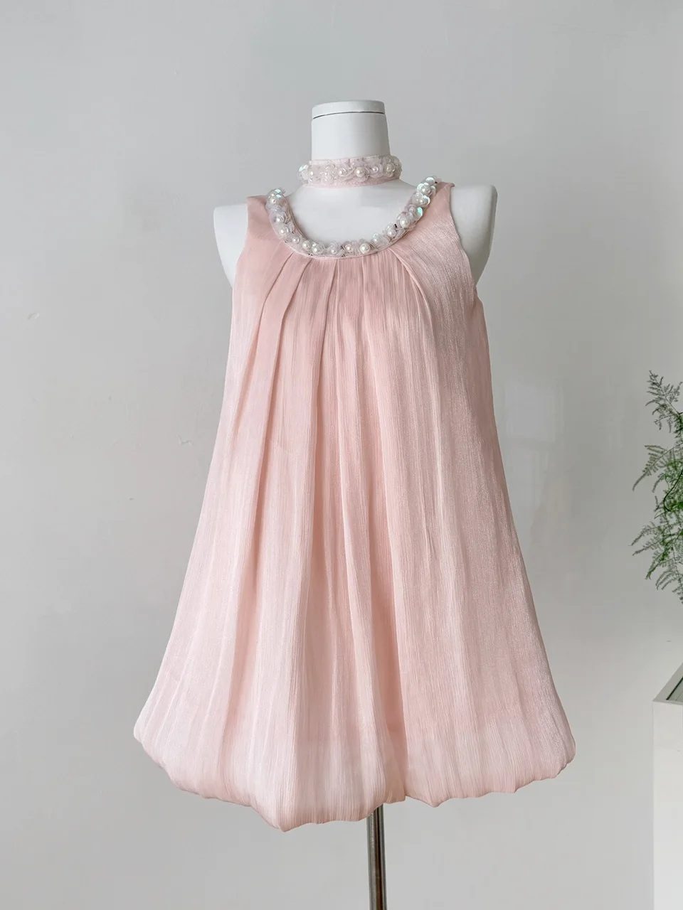 فستان نسائي صيفي فاخر بخيوط لامعة وزخارف ثقيلة، تنورة قصيرة بتصميم A-Line وخصر مرتفع، بلون وردي ناعم مع زخارف على شكل براعم ز...
